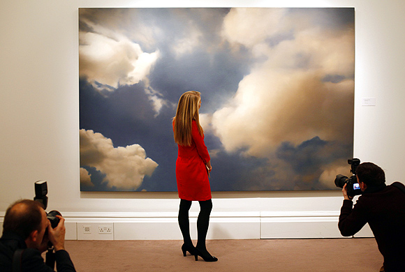 A Sotheby's worker poses next to Wolke (Cloud) from 1976 by Gerhard Richter, at Sotheby's in London.
