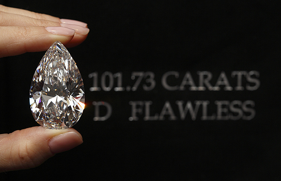 A Christie's member of staff displays a pear-shaped, D colour, flawless diamond of 101.73 carats during an auction preview in Geneva.