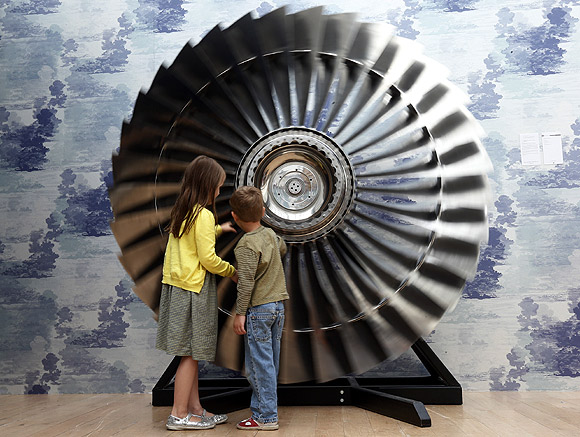 Riva Lemanski 6, and her brother Elia 4, turn a Stage 1 Rolls Royce RB Titanium Turbine Fan from 1970 at Christie's in London.