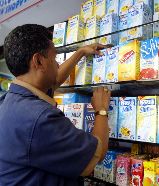 A worker at a shopping mall adjusts packs of various milk products in Mumbai.