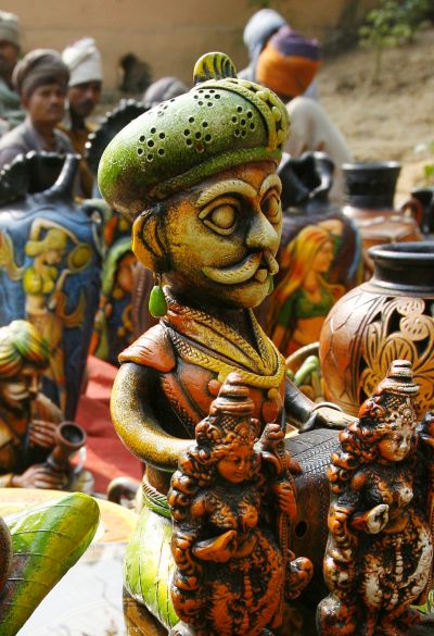 Labourers sit near a stall of sculptures at the Surajkund Crafts Fair in the northern Indian state of Haryana.