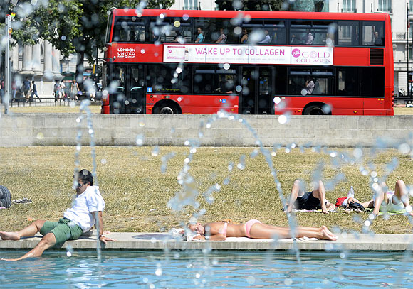 People sit by a pond at Marble Arch, in central London.