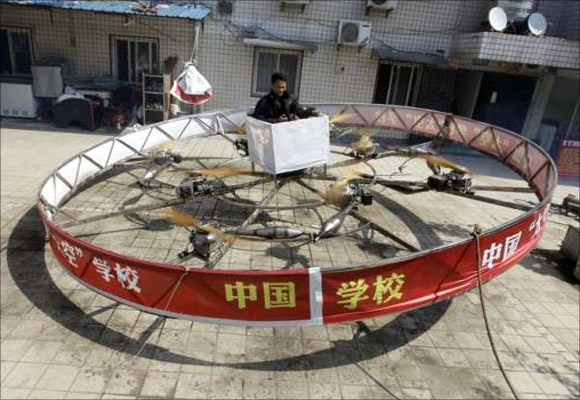 Local farmer Shu Mansheng hovers above the ground in his self-designed and homemade flying device during a test flight in front of his house in Dashu village on the outskirts of Wuhan, Hubei province.