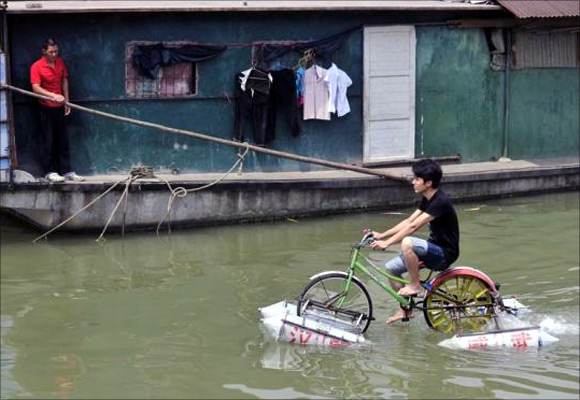 Lei Zhiqian rides a modified bicycle across the Hanjiang River, a tributary of the Yangtze River in Wuhan, Hubei province, China.