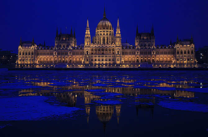 Hungarian Parliament building is reflected on the icy Danube river in Budapest.