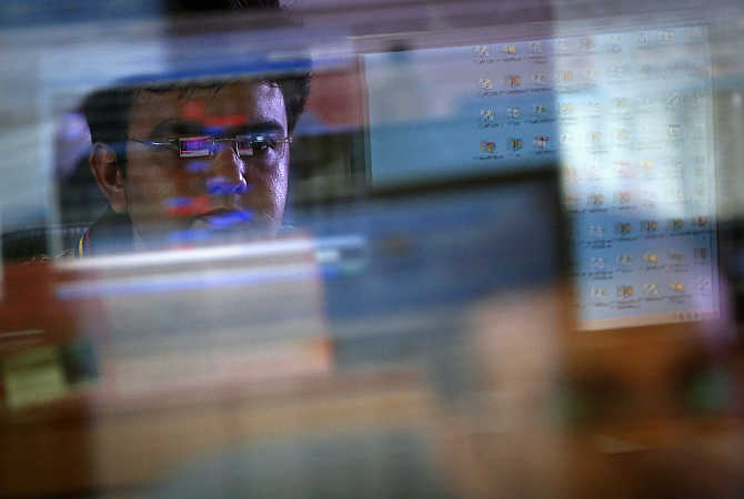 A broker monitors share prices while trading at a firm in Mumbai.
