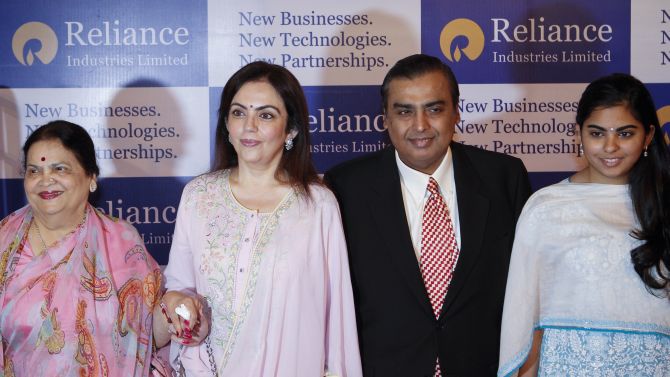 Mukesh Ambani, chairman of Reliance Industries Limited, poses with his mother Kokilaben Ambani (L), wife Nita Ambani (C) and daughter Isha Ambani (R) before addressing the annual shareholders meeting in Mumbai.