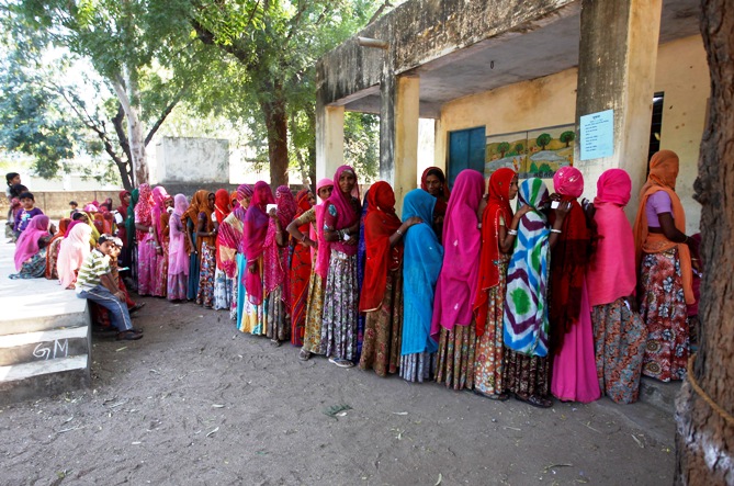 Voters line up in a queue outside a polling booth to cast their vote during the state assembly election in Maval town, located in the desert Indian state of Rajasthan, December 1, 2013.
