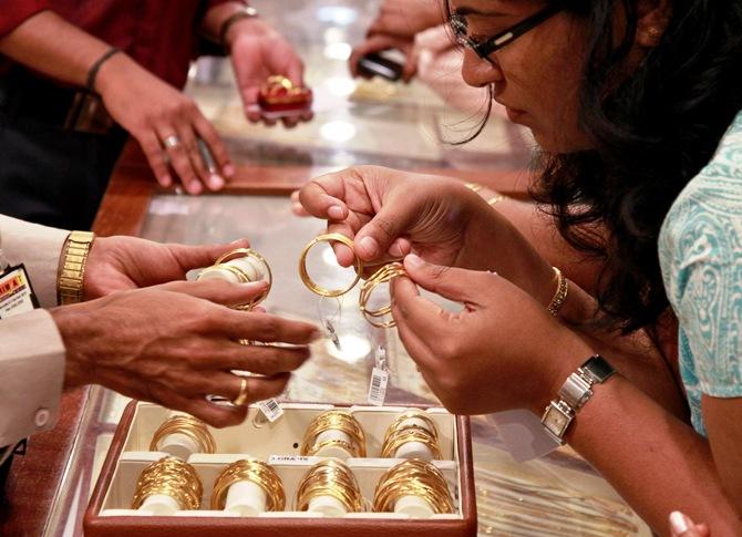 A customer looks at bangles before purchasing them at a gold showroom in Kochi.