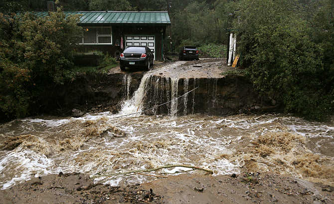 A home and car are stranded after a flash flood in Coal Creek destroyed the bridge near Golden, Colorado, United States.