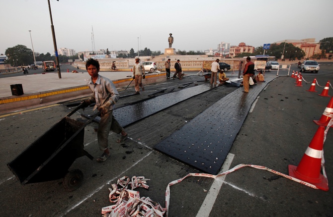 Labourers work at a road construction site outside Ambedkar memorial park in Lucknow.