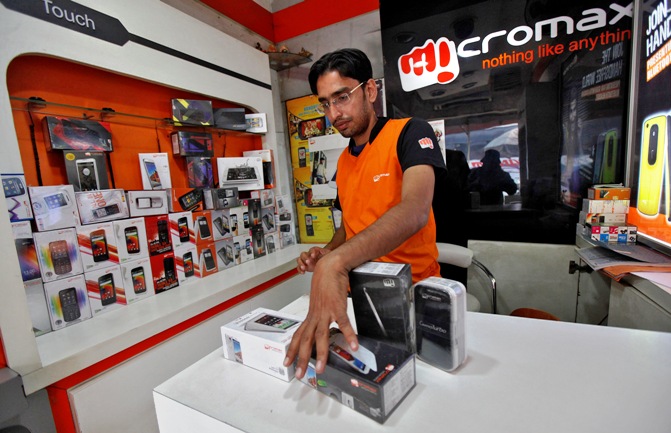 A worker displays a Micromax mobile phone inside a store in Kolkata.