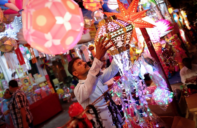 A vendor hangs a lantern for sale at a Diwali market in Mumbai.