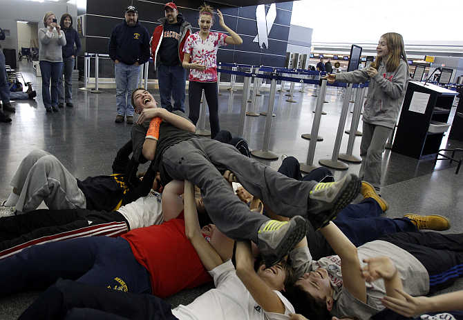 Members of the Skaneateles Bantam ice hockey team do a calisthenics drill to pass the time at JFK International Airport in New York.