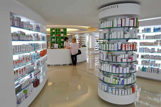 An employee talks with a customer inside a pharmacy in the Glyfada suburb of Athens, Greece.