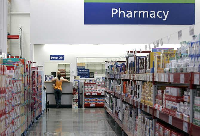 A customer leans against the pharmacy counter at a Sam's Club store in Bentonville, Arkansas.