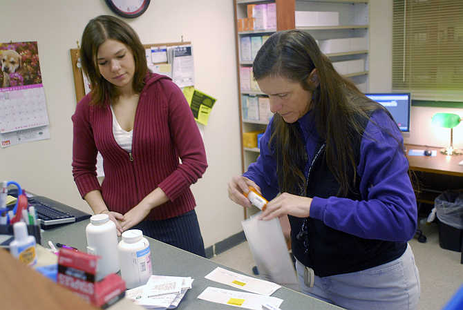 Pharmacist Susan Lattier, right, fills prescriptions as technician Ashley Smith, left, looks on at a pharmacy in Cincinnati, Ohio.