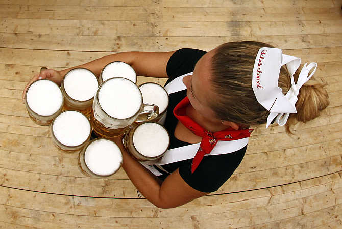 A waitress carries the traditional one-litre beer mugs at Munich's beer festival in Germany.