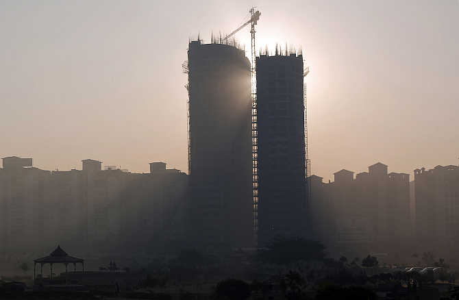 Sun rays beam through two under construction residential buildings in Noida.