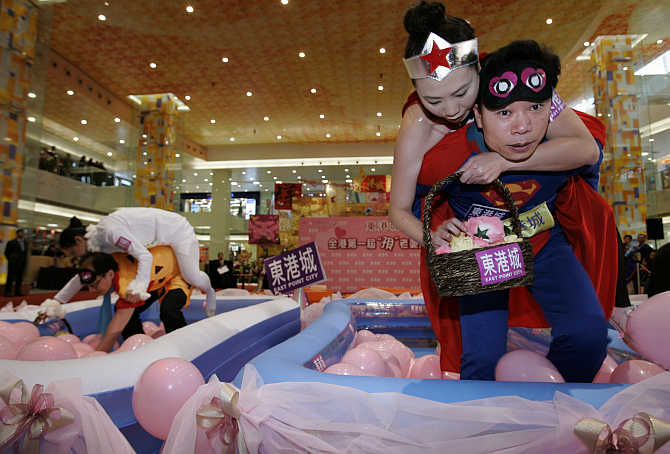 Participants compete in a wife-carrying obstacle race at a shopping mall in Hong Kong.