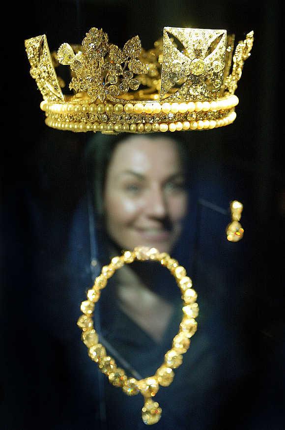 A woman looks at the Diamond Diadem Crown (1820), which belongs to Britian's Queen Elizabeth II, at the Queen's Gallery at Buckingham Palace in London.