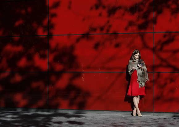 A woman uses her mobile phone in central London.