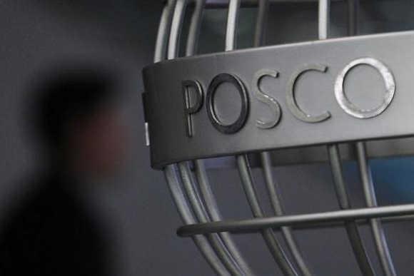 A man walks past a Posco logo at the company's headquarters in Seoul, South Korea.