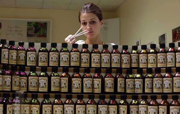 Caroline De Boutiny, the perfume creator or 'nose' at the Galimard perfume factory, holds paper scent testers as she smells different essences from behind bottles at her composer's organ in Grasse, south-eastern France.