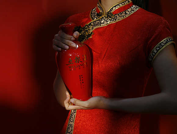 An attendant holds a bottle of Wuliangye, one of China's most famous liquors, during the opening of its flagship store in Hong Kong.