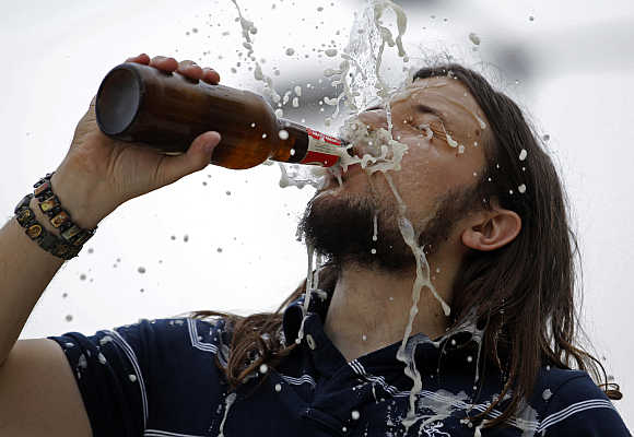 A man drinks a beer during during a wrestling show in Budapest, Hungary.