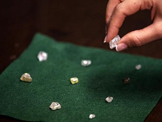 A visitor holds a 17 carat diamond at a Petra Diamonds mine in Cullinan, outside Pretoria.