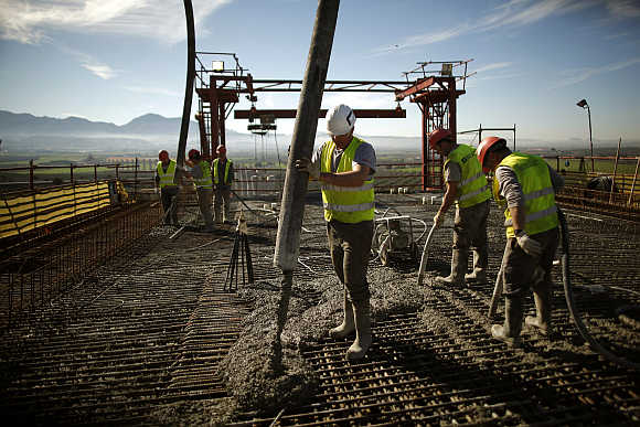 Workers pour concrete on a platform at the construction site of the Guadalhorce river viaduct for the Granada-Malaga high-speed train AVE line near Antequera, southern Spain.