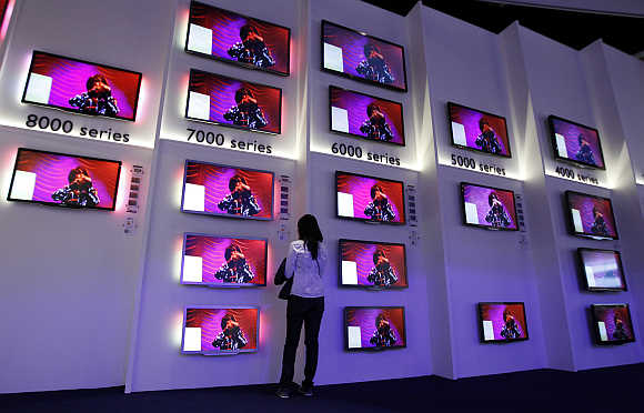 A woman looks at flat screen TV sets in Berlin, Germany.