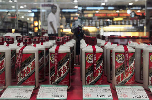 A customer walks past a glass case displaying Maotai liquors at a supermarket in Shenyang, Liaoning province.