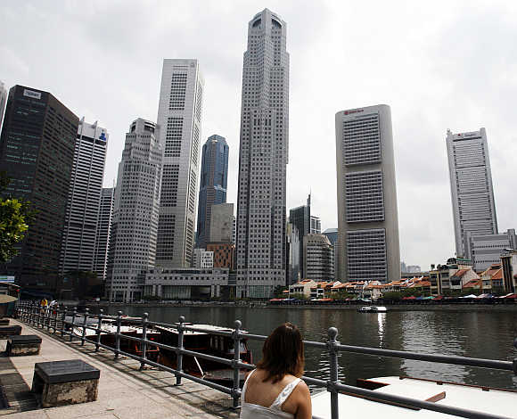 A woman looks at the skyline of Singapore's financial district.