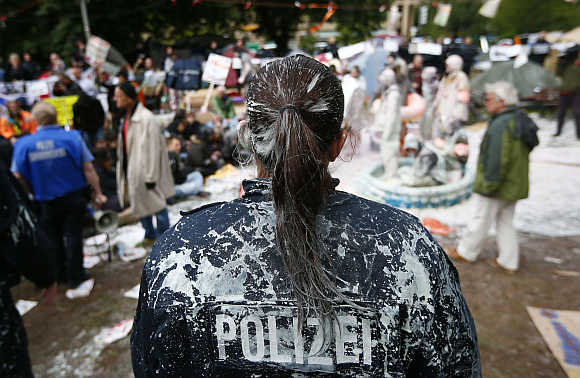 A police woman is covered with paint after being attacked by demonstrators in Frankfurt.