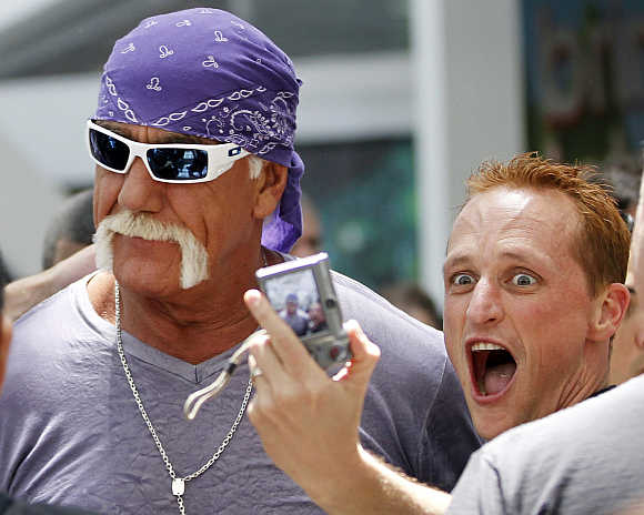 A fan takes a photo with wrestler Hulk Hogan in Los Angeles.