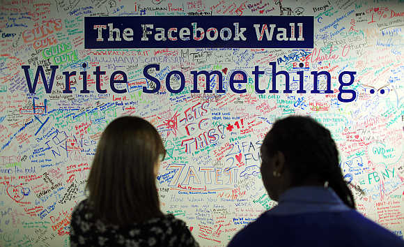 People look at the Facebook wall at their office in New York.