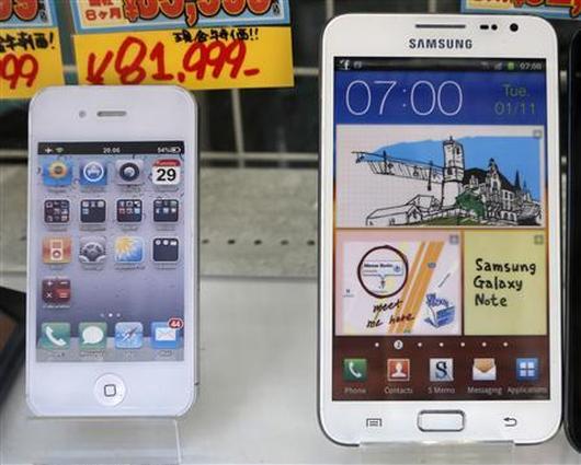 Apple's iPhone, left, and 5.3-inch Samsung Galaxy Note are displayed at a shop.