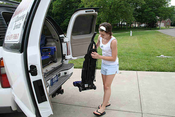 Lacie Baldwin removes a vacuum cleaner from Chevrolet Suburban in Lawrenceburg, Indiana, United States.