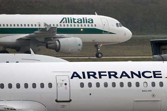 An Alitalia plane passes an Air France plane on the tarmac of Charles de Gaulles International Airport in Roissy near Paris.