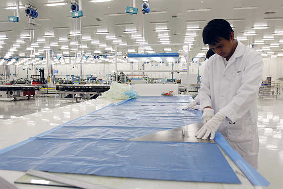 An operator cuts through a sheet of carbon fiber at Strata, a composite aerostructures manufacturing plant, in Abu Dhabi, UAE.