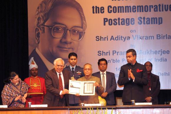 President Pranab Mukherjee, with Kapil Sibal on left and Milind Deora on right, released postage stamp on Aditya Vikram Birla.