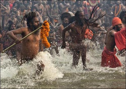 Naga Sadhus take a dip during the first Shahi Snan (grand bath) at the ongoing Kumbh Mela in Allahabad on January 14, 2013.