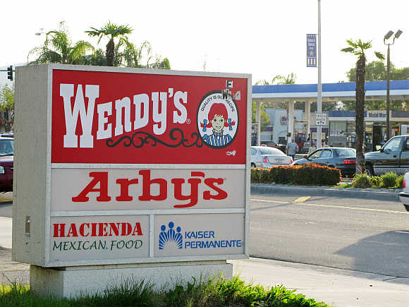 A combined Wendy's/Arby's sign is shown near a restaurant in Fontana, California, United States.