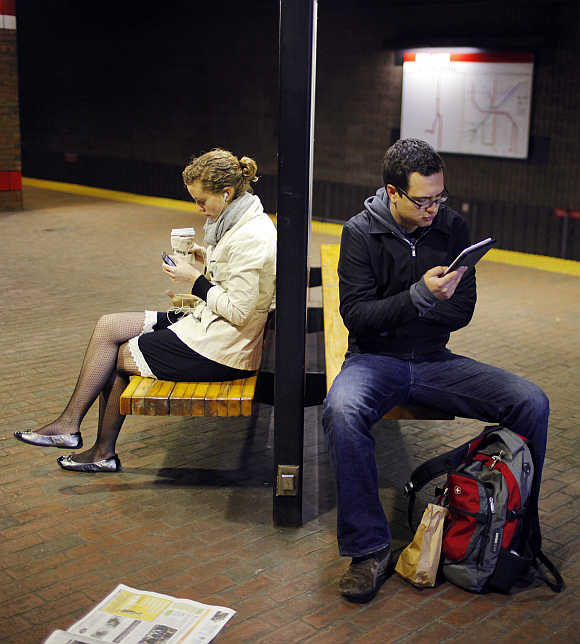 A commuter reads on a Kindle e-reader while waiting in the subway in Cambridge, Massachusetts, United States.