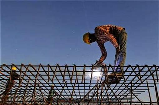 A worker welds iron rods at a construction site in Ahmedabad.