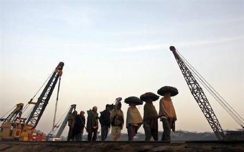 Labourers arrive for work at a railway yard in Chandigarh.