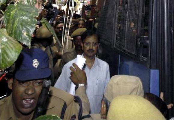 File photo shows Ramalinga Raju (C), founder and former chairman of fraud-hit Satyam Computers, being escorted from a court in Hyderabad.