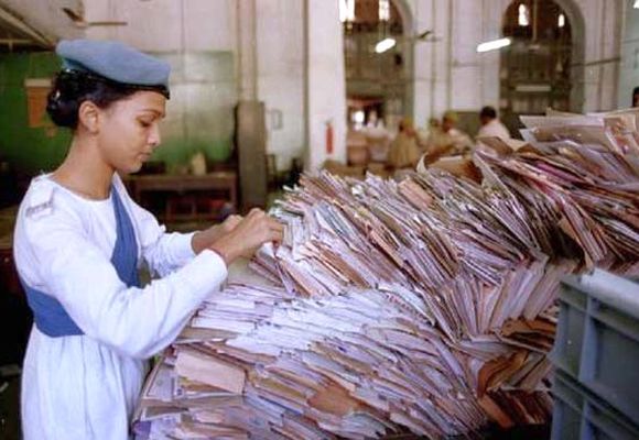 A home guard volunteer sorts mail in Bombay's main post office.
